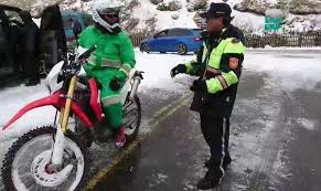 花蓮國安郵局外包投遞士游如鈁 奔波在皚皚白雪中的翠綠色身影 被一旁賞雪民眾及警方讚譽 史上最強郵差 記者王峻祺翻攝 moped motorcycle vehicles