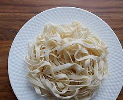 Thick-cut, fresh uncooked noodles ready for cooking.