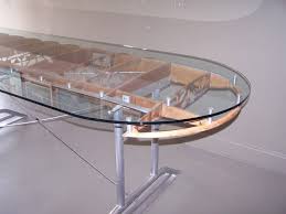 Long biomorphic coffee table with stacked rattan legs and a dark stained wood top with a rattan trim along the borders. Airplane Wing Tables