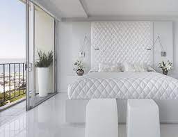 Large primary bedroom with a beige color scheme, rock wall with gas fireplace, french doors. 50 Best Bedrooms With White Furniture For 2021