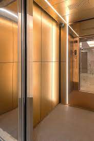 Levele 105 Elevator Interior With Customized Panel Layout Panels In Fused Bronze With Seastone Finish Fused Elevator Design Elevator Interior Custom Lighting