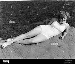 Schwarz-weiß Foto mit einem geschweiften behaarte Frau, in voller Länge,  Draußen, liegen auf einer Decke in einer grünen Umgebung, trägt einen  hellen Unterwäsche oder Badebekleidung, wahrscheinlich in Ohio in den zehn  Jahren