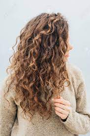 Collection by nancy hernandez • last updated 5 weeks ago. Curly Brunette In A Sweater On The Coast Holding Hair With Her Stock Photo Picture And Royalty Free Image Image 59182417