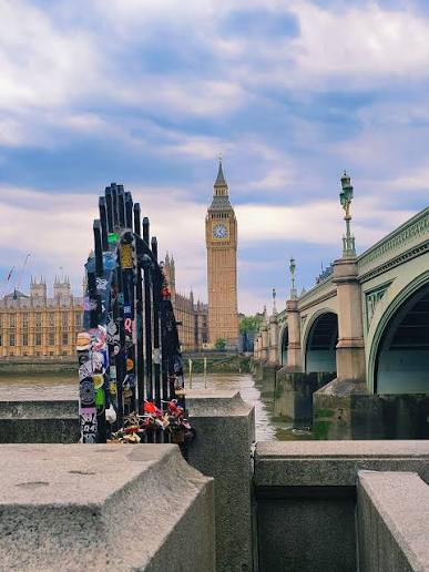 This photo showcases the Palace of Westminster and its famous clock tower,  the Elizabeth Tower, which houses the Great Bell known as Big Ben. The  image was captured from Westminster Bridge, a