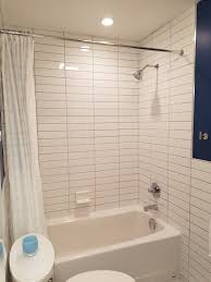 White wall tiles create a light and bright aesthetic in your room, whether it be in your bathroom or kitchen. American Standard Cambridge Tub Tile From Tub To Ceiling White Vanity Blue Walls Pivo White Subway Tile Bathroom Bathroom Wall Tile Bathroom Remodel Shower