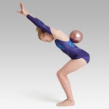 Beautiful gymnast in sports outfit with a ball performs an element of rhythmic gymnastics on a gray background. 18 5 Cm Fig Approved Rhythmic Gymnastics Ball Gold Pink
