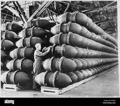 A woman war worker checks over 1,000-pound bomb cases before they are  filled with deadly charges of explosives and shipped off to Allied bases  and battlefronts all over the world. Firestone Tire