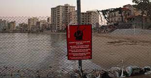 A woman walks past abandoned buildings in varosha. Fumlauesn Cpsm