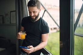 Add pressurised gas to orange juice you get orangeade. Young Man Drinking An Orange Juice And Using His Smartphone At The Window Stockphoto