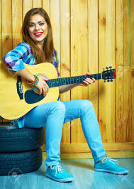 Fingerpicking and using a pick Girl Hold Guitar Sitting On A Car Wheels Against Wooden Background Stock Photo Picture And Royalty Free Image Image 85580320