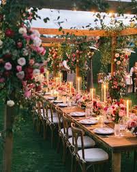 Gorgeous Outdoor Dining Setup With Pink Red And White Roses And Greenery On The Table And The Wo Candlelit Wedding Candlelit Wedding Reception Wedding Lights