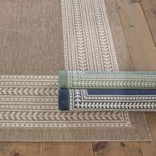 The airy medallion motif was inspired by a piece of antique fabric. Suzanne Kasler Fleur Indoor Outdoor Area Rug