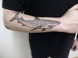 Shark with a floral pattern tattoo on the left arm. 45 Awesome Shark Tattoos For Your Inner Badass