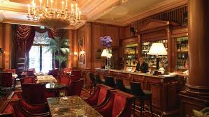 The interior is centred on a dramatic double height bar space featuring a fluted glass screen illuminated from behind with filament bulb lighting and a bespoke floor mosaic signature george's 'g'. Bar Lounge Champs Elysees Le Bar At Four Seasons Hotel