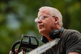 Dan Warther carving 7 sets of pliers into tree at museum