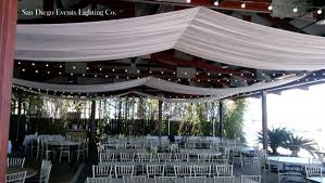 Wood beam ceiling with draped textile. Bali Hai Ceiling Draping With Market Lights For San Diego Wedding