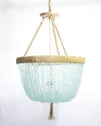 Beach chandeliers are often soft and airy, made of materials such as wood and shell, to invite a sense of calm into your home. Cynthia Sea Glass Nugget Open Chandelier Au Courant Interiors