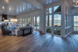 As A Bridge Between Indoors And Outdoors Floor To Ceiling Windows Introduce Light Views And A C Waterfront Homes Waterfront Homes For Sale Coastal Interiors