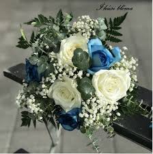 A bouquet made of large pinecones, evergreens and baby's breath for a rustic winter bride. Wedding Bouquet With Blue And Cream Roses Accented With Baby Breath And More I Husi Bloma Flower Delivery Shop Iceland