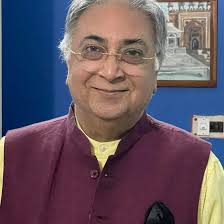 A rare photo indeed! Professor Barun De stands in a pandal during the 49th  Indian History Congress Seesion held at Dharwar in 1988. On the chair sits  another stalwart of that time: