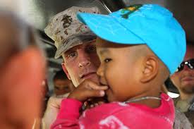 U.S. Marine Col. John Ostrowsky, center, humanitarian