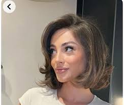 Who is a budget-friendly hairstylist for haircut and grad photos?