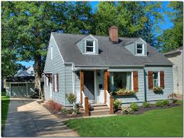 Bungalow Renovation With Gray Siding Wood Board And Batten Shutters Portico And Window Boxes House Exterior Blue House Shutters House Exterior
