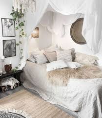 Chic blue bedroom boasts a black canopy bed dressed in white scalloped bedding and placed on a gray rug behind a blue velvet tufted bench. 34 Awesome Boho Chic Bedroom Decor Ideas Homyhomee