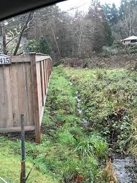 Place riprap rocks into the ditch, building in layers and ensuring that larger rocks are lower than smaller ones in the ditch. Undeveloped Land Purchased For New Home Build Drainage Ditch Creek Runs Length Of Neighbor S Fence Line Our Eventual Plan Is To Dig It Out More And Line It With Rock To Make It
