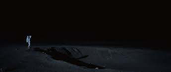 Neil armstrong in his spacesuit standing on the lip of a crater on the moon, holding a bracelet spelling out the name of daughter karen, who had died seven years earlier, before her third birthday. One Small Step Recreating The Historic Lunar Landing For First Man Animation World Network