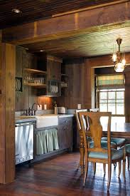 Dark wood covers the floor, kitchen cabinets, and ceiling in this moody rustic home. Cabin Style Decorating Ideas Town Country Living Small Cabin Kitchens Rustic Cabin Kitchens Cabin Kitchens