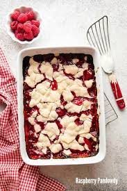 Freshly Baked Raspberry Pandowdy Dessert In A White Baking Dish With A Bowl Of Fresh Raspberries Red Gingha Raspberry Recipes Fresh Raspberry Recipes Desserts