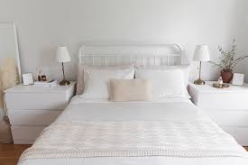 Gorgeous details in white bedroom with dark curtains, chandelier, dark grey pintuck bedding, and an iron bed frame. White Bedroom Decorating Ideas