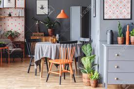 Touch device users, explore by touch or with swipe gestures. Orange And Black Chair At Table In Grey Retro Dining Room Interior With Plants And Posters Stock Photo Picture And Royalty Free Image Image 107365895