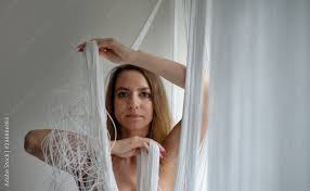Foto Stock Portrait einer schönen jungen attraktiven sexy Frau, nackt,  verdeckt, spielt mit den Händen dekorativ mit den weißen Fäden eines  Fadenvorhangs | Adobe Stock