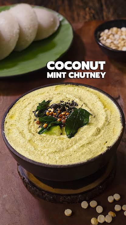 Freshly ground white coconut chutney in a copper bowl with mustard seed tempering on top alongside crispy masala dosa
