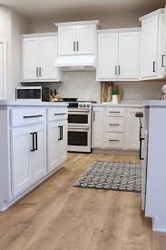 Modern Farmhouse Kitchen With White Cabinets And Black Hardware And Farmhouse Style Accents From Laminate Kitchen Cabinets Buy Cabinets Diy Kitchen Cabinets