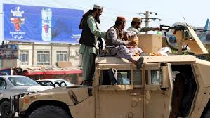 A taliban fighter stands guard over surrendered afghan security member forces in the city of ghazni, southwest of kabul, afghanistan, on friday. Nau6bj Kvrounm