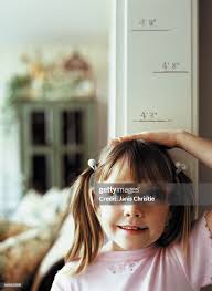 Young Girl Measuring Height On Wall High Section High-Res Stock Photo