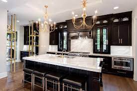 White and gray painted cabinets, countertop and backsplash choices and update ideas for decorating a white or gray kitchen with black appliances. Gold And Black Kitchen With Thick White Marble Countertops Contemporary Kitchen