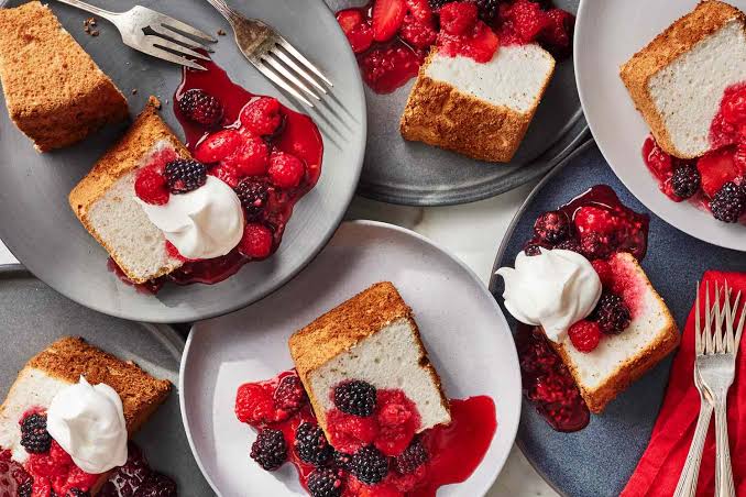 Angel Food Cake slice served with fresh berries and whipped cream