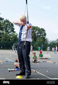 Prime Minister Boris Johnson takes part in archery during a visit to the  Premier Education Summer Camp at Sacred Heart of Mary Girl's School,  Upminster in Essex Stock Photo
