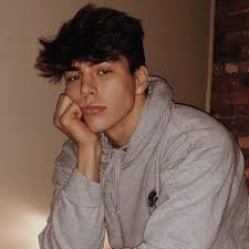 Caucasian boy in shirt with curly hair posing at camera isolated over green background. Cute White Boy With Curly Brown Hair Novocom Top