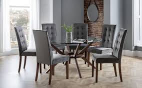 This large round dining table constitutes a stylish wooden proposition, that reflects well the traditional style in design. Julian Bowen Chelsea 140cm Round Glass Dining Set With 6 Madrid Chairs First Furniture First Furniture