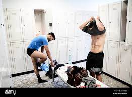 Two men changing in the locker room at the gym Stock Photo - Alamy