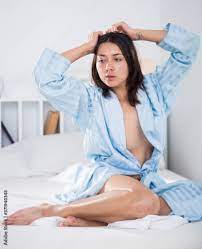 Seductive nude young sexy girl in bathrobe playfully posing in bed at home  Stock Photo | Adobe Stock