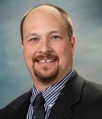 WMU's President, Dr. Edward Montgomery, driving the Bronco Baja vehicle in  front of The College of Engineering and Applied Sc