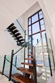Glass staircase walls make excellent additions to old and historic structures which often include dark and gloomy spaces. Tall Vertical Window On The Stairwell Usual House Staircase Design Stairs Design House Design