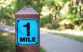 The statute mile was standardised between the british commonwealth and the united states by an international agreement in 1959, when it was formall. A One Mile Marker Sign Post Beside A Paved Pathway With A Bright Green And Sunny Background Stock Photo Picture And Royalty Free Image Image 98979328