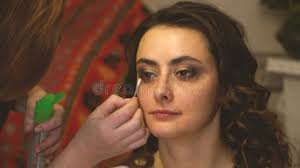 Makeup Artist with a Brush Puts Dark Shadows